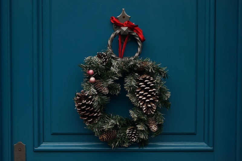 holiday wreath with pine cones on blue door