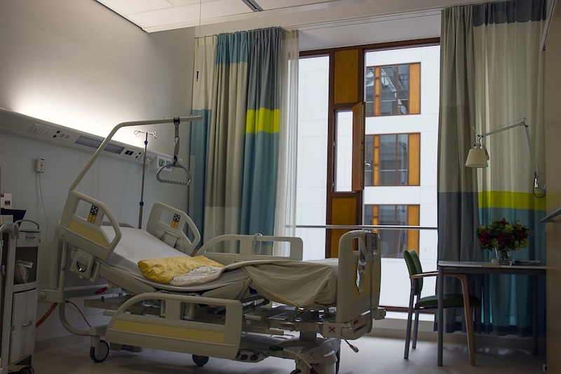 hospital room with large window and hospital bed