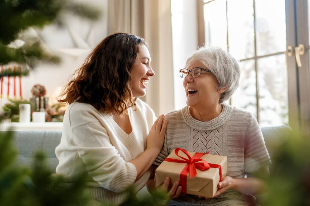 Daughter with elderly mother exchanging presents